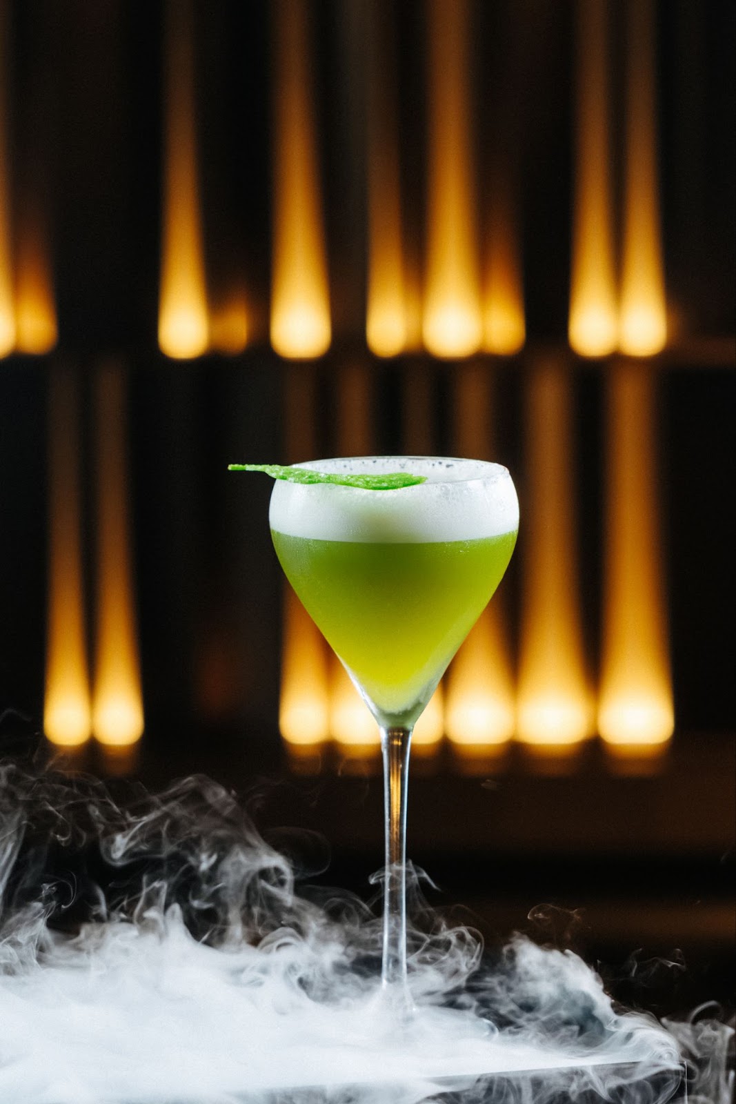 Green cocktail with foam leaf smoke lights